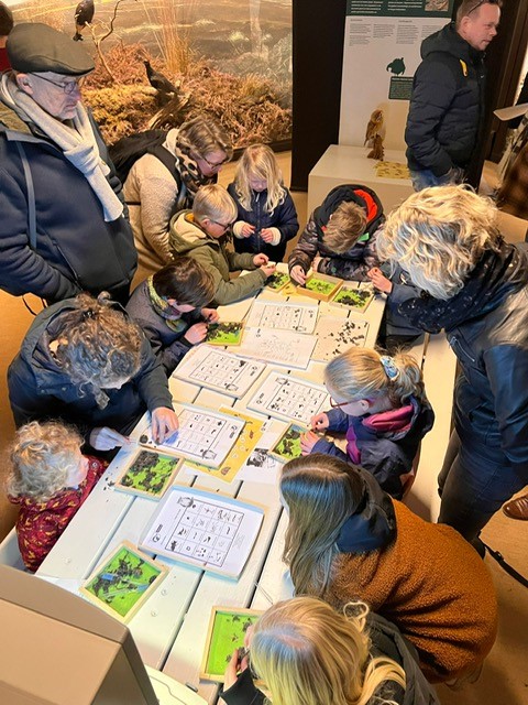 Een schoolgroep onderzoekt samen uilenballen in het museum